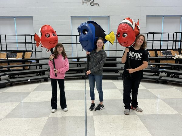 Lila McConnell (10), Halle Colabray-Whitmire (10), and Tristan Walsh (9) hold the puppets they will use in the play.