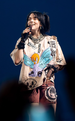 Billie Eilish happily singing to a crowd of her fans.