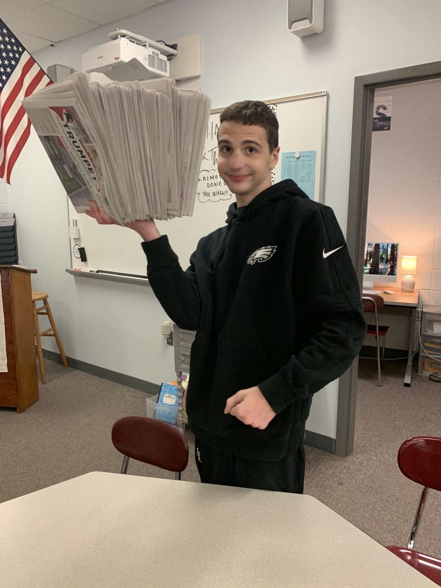 Max Averbach (12) holds 100 newspapers in one hand, an amount that could be a world record.