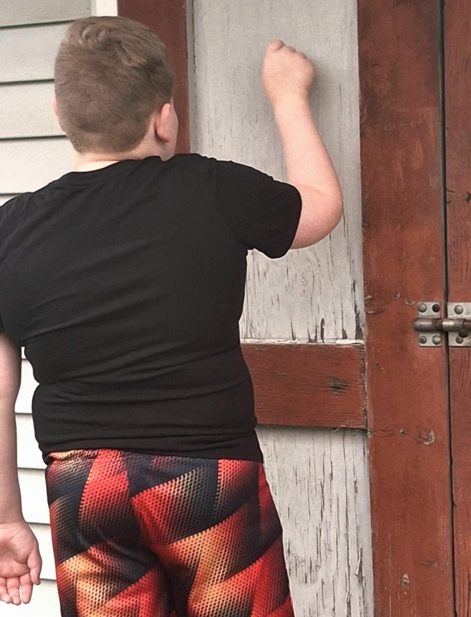 A child knocks on the door of a home while trick or treating.