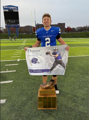 Ty Tremba poses with a sign on the field after breaking the all-time passing record at Franklin and Marshall College. 